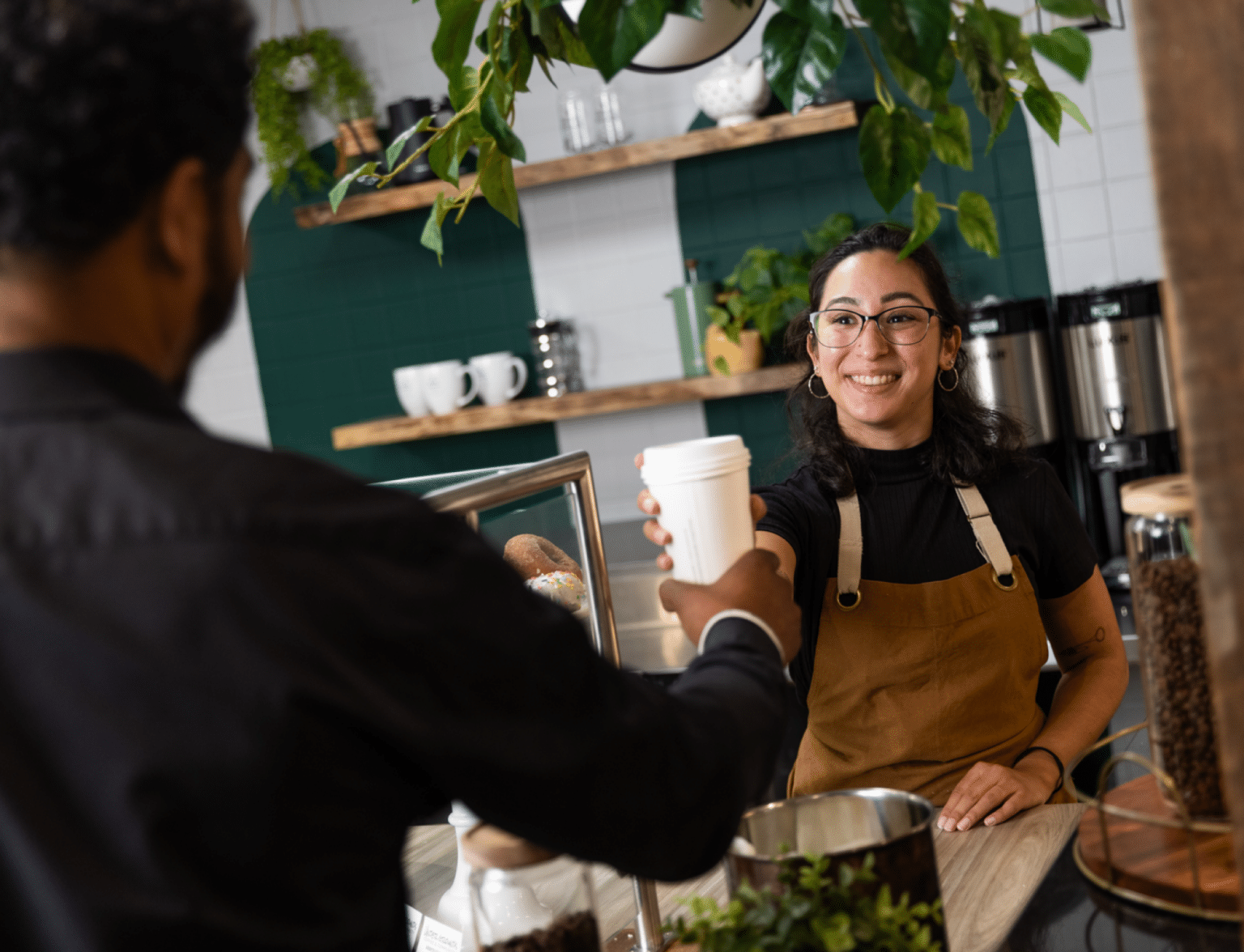 Female Barista Smiling Female barista smiling and handing a customer a cup of coffee