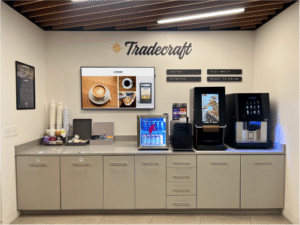 Tradecraft breakroom in an office with coffee makers, a tv on the wall, and the Tradecraft logo