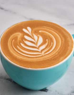 Coffee with latte art in a blue mug