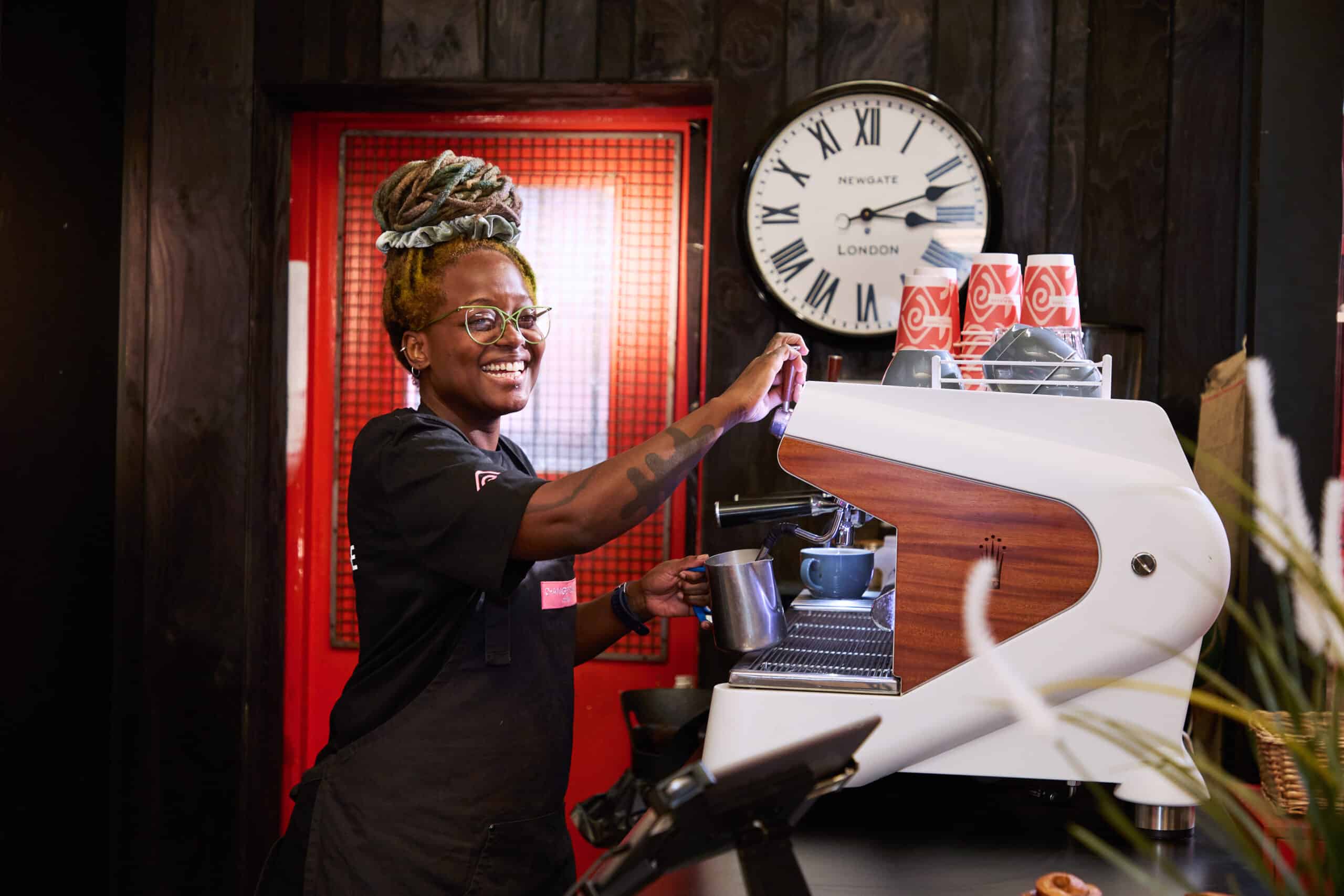Chang Please female barista smiling and making coffee